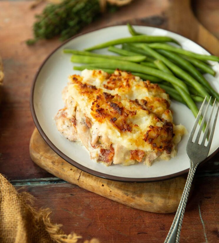 chicken and bacon pie on small white plate served with green beans