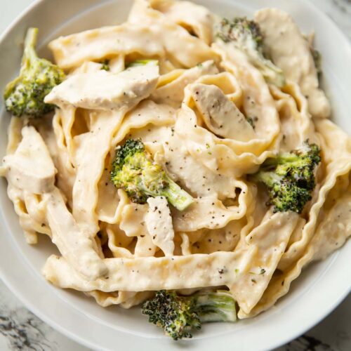 close up shot of pasta with chicken and broccoli in large white dish
