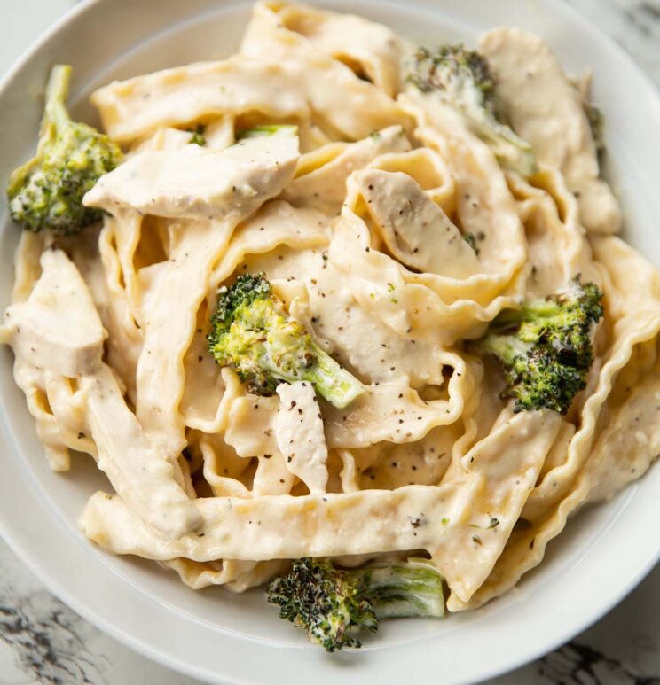 close up shot of pasta with chicken and broccoli in large white dish