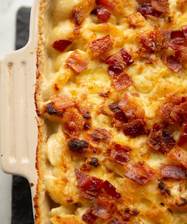 close up shot of cauliflower cheese pasta fresh out the oven garnished with bacon