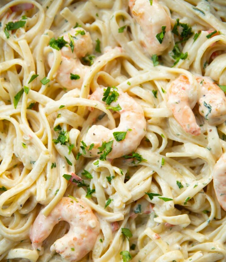 close up shot of prawn linguine in skillet garnished with fresh parsley