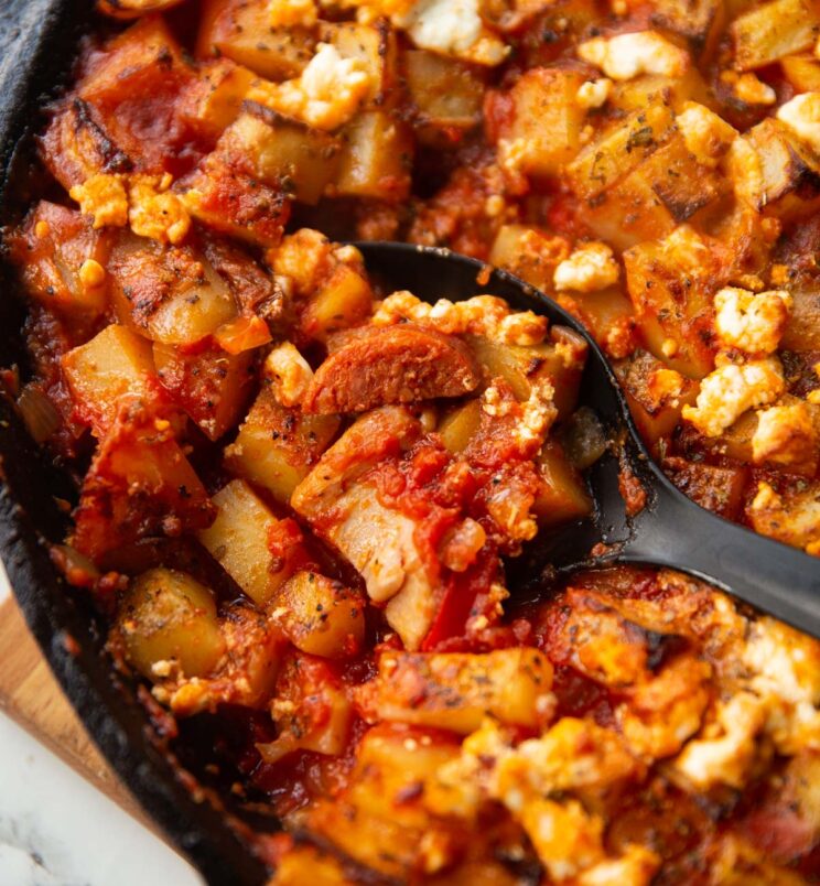 close up shot of black serving spoon digging in to chicken chorizo bake