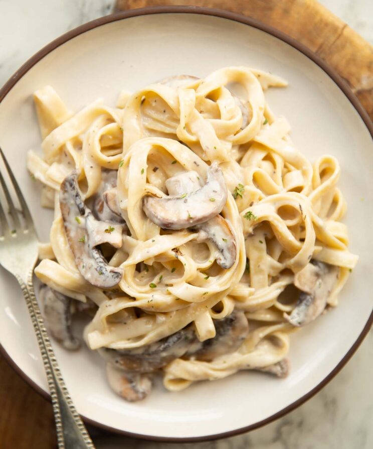 overhead shot of mushroom tagliatelle on small white plate with silver fork