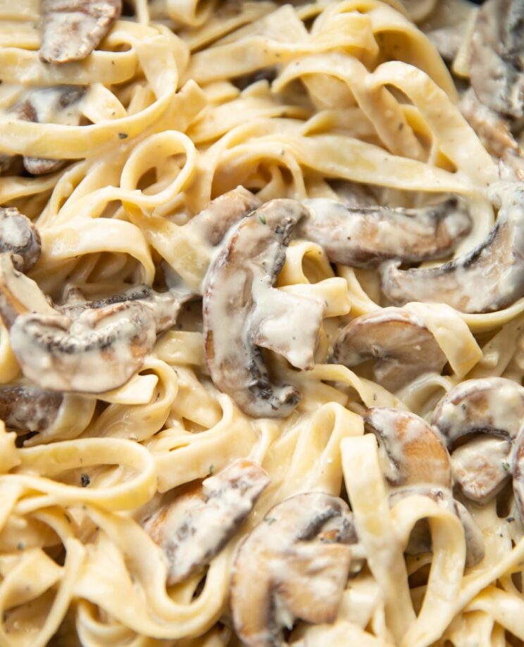 close up shot of tagliatelle with mushrooms in skillet