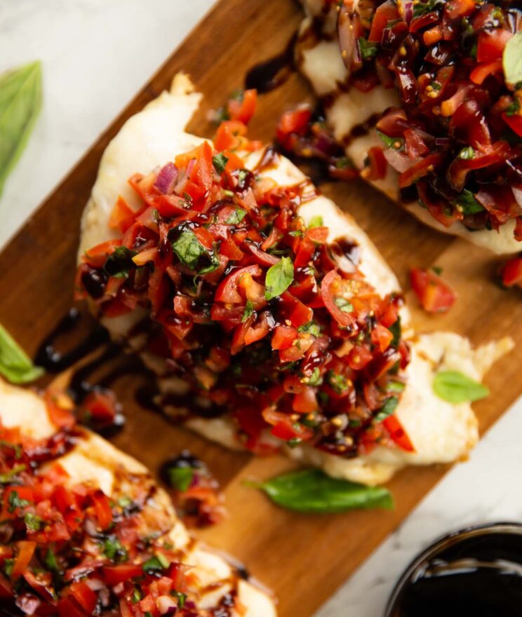 close up overhead shot of bruschetta chicken on wooden board