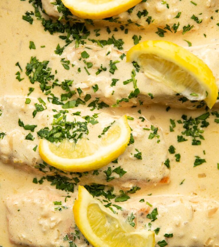 overhead shot of 4 salmon fillet sin lemon cream sauce in pan