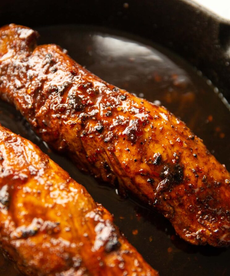 close up shot of honey cajun butter pork tenderloin in cast-iron pan