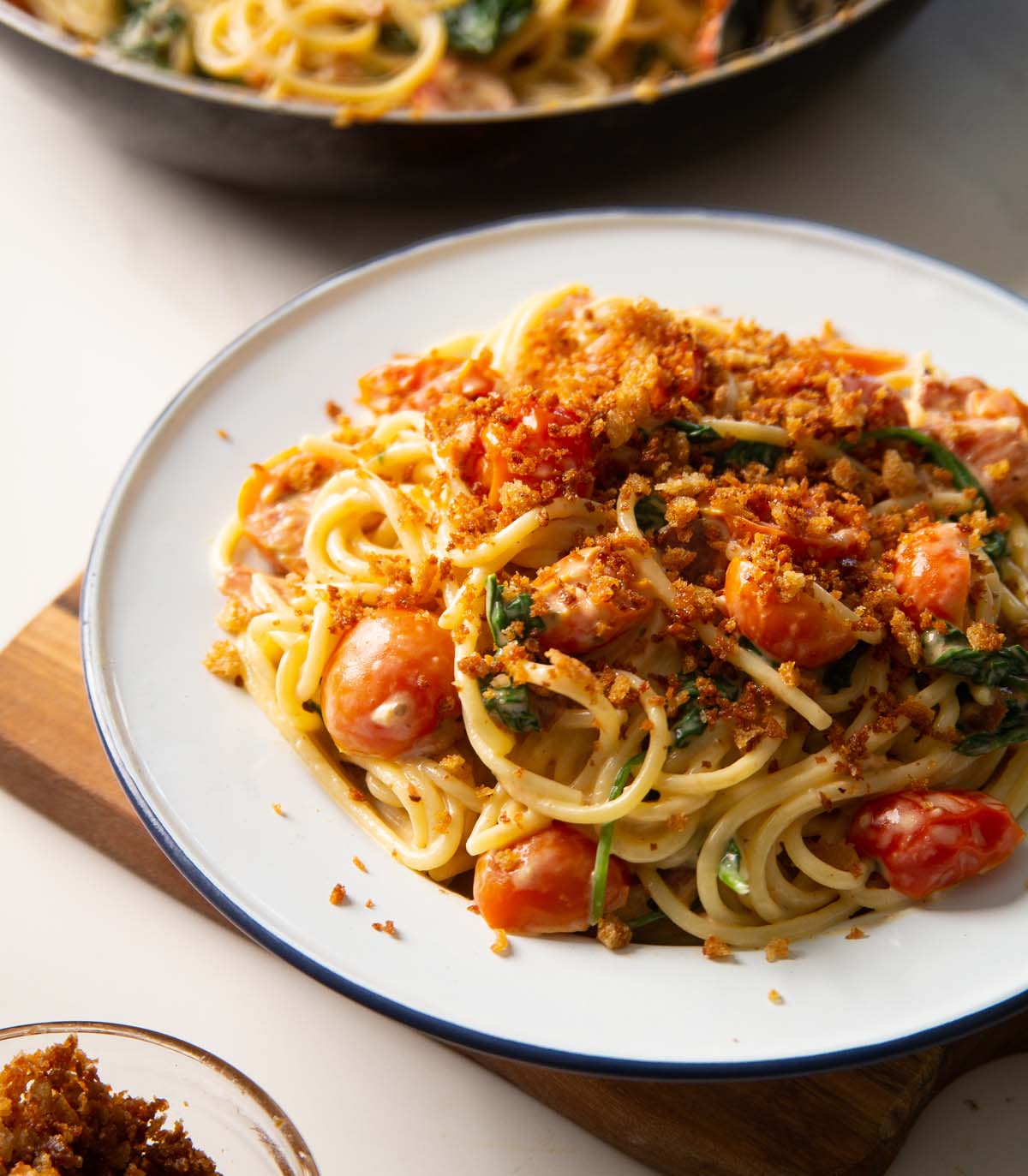 side shot of blt pasta in white dish with toasted breadcrumbs