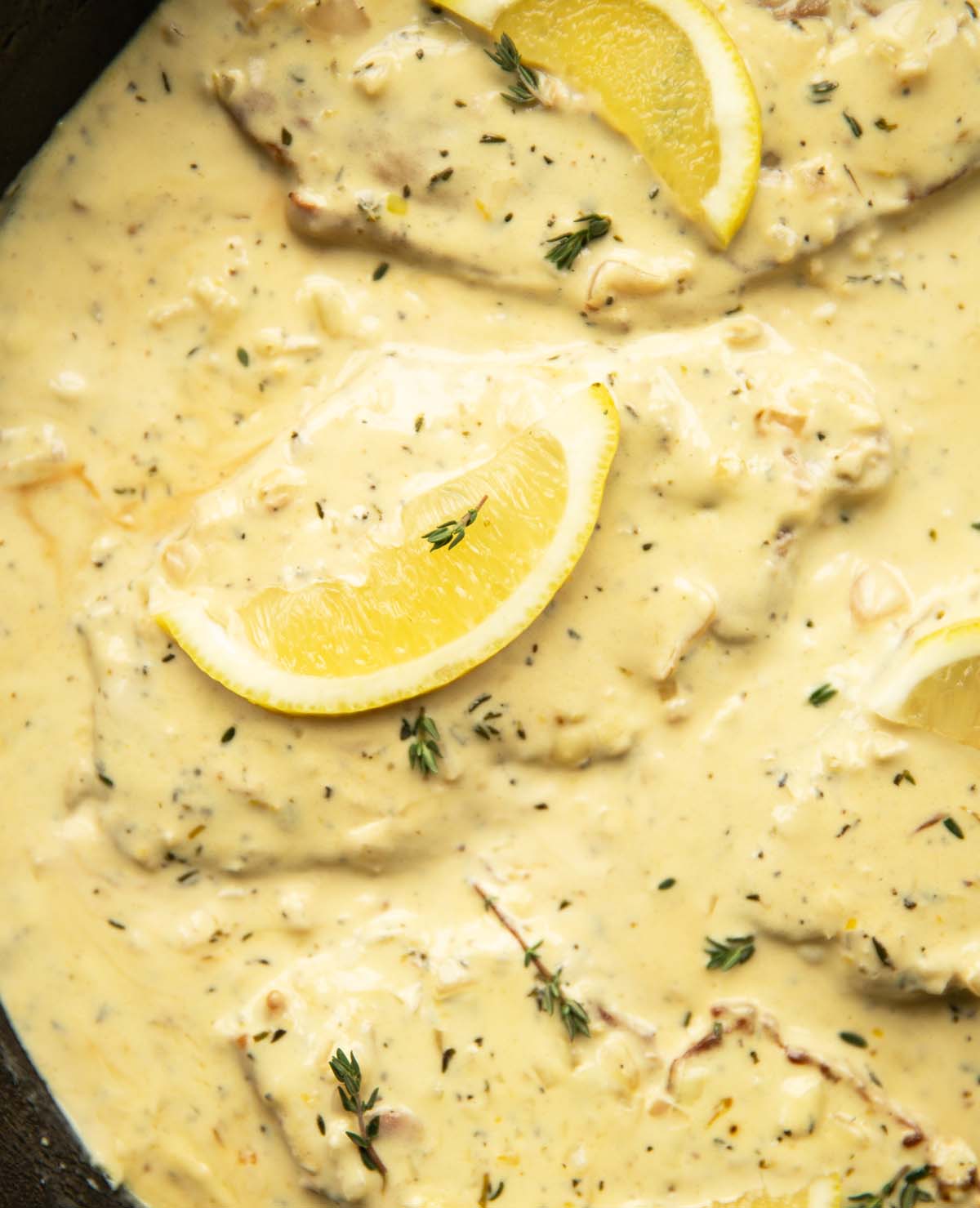 overhead shot of creamy lemon thyme pork in large cast-iron pan