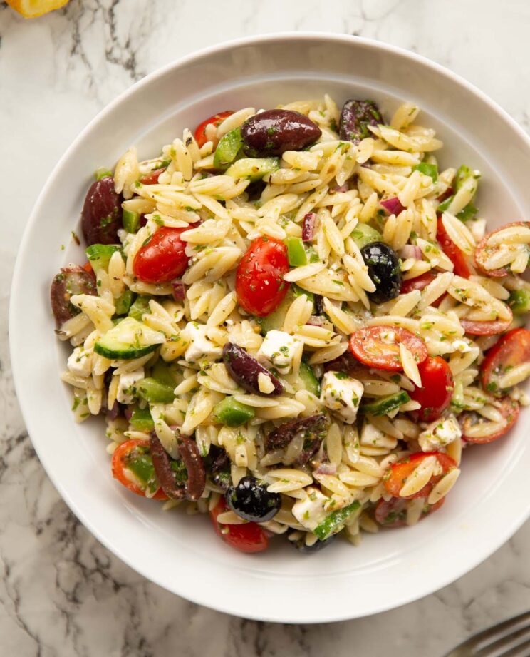 overhead shot of greek orzo pasta salad in large white bowl