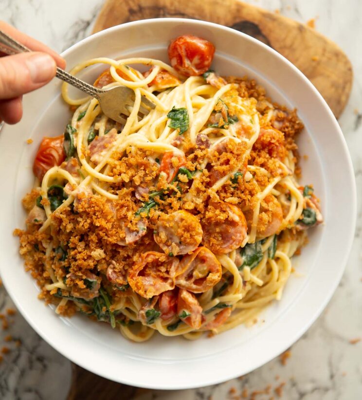 overhead shot of hot blt pasta in large white bowl garnished with toasted breadcrumbs