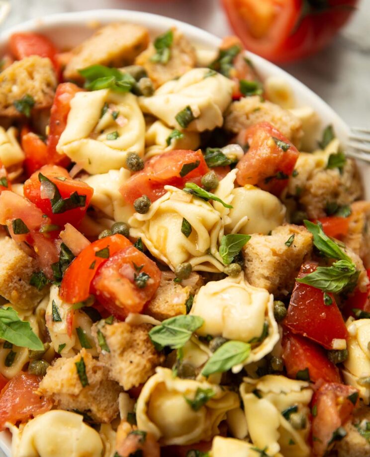 close up shot of panzanella tortellini pasta salad in large white dish