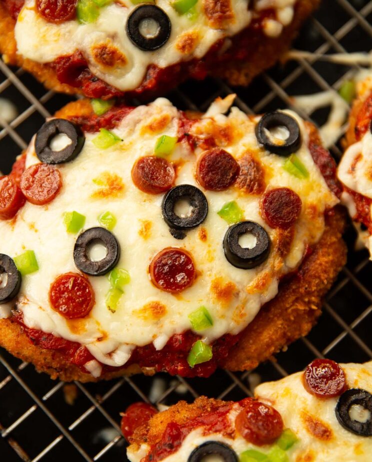 close up shot of pizza chicken parmesan fresh out the oven on wire rack