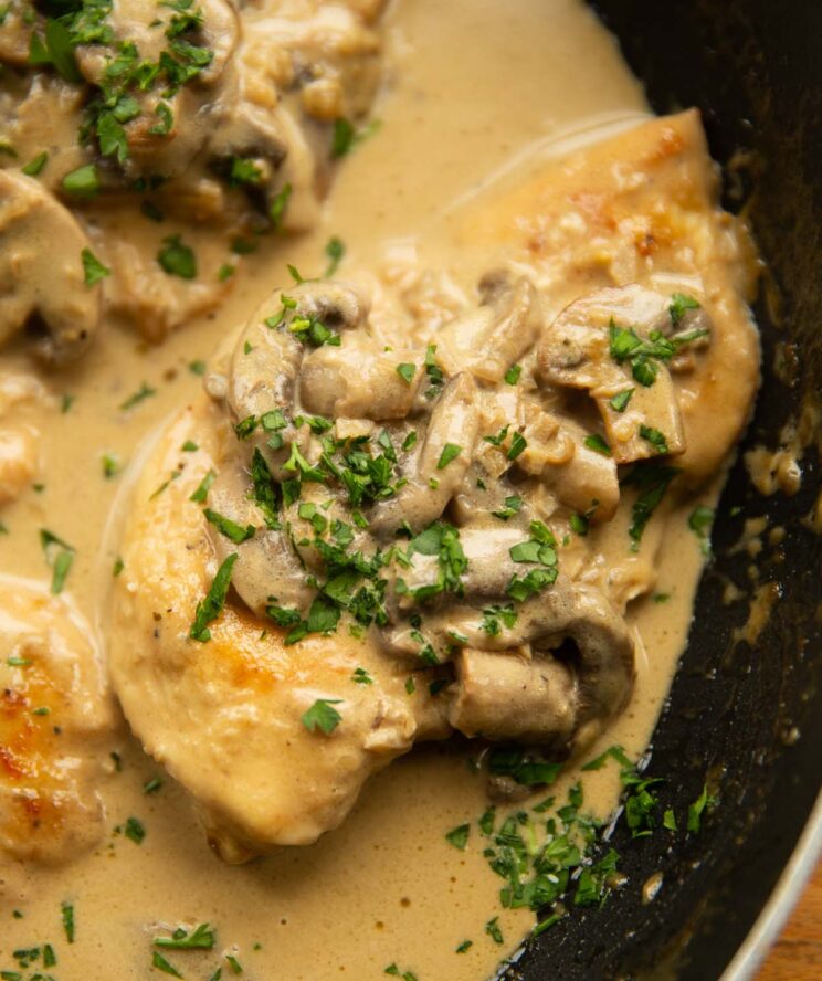 close up shot of chicken marsala in pan garnished with parsley