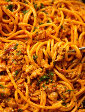 close up shot of fork twirling into pan of sausage harissa pasta