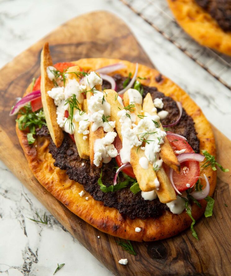 close up shot of unfolded beef gyros on wooden board