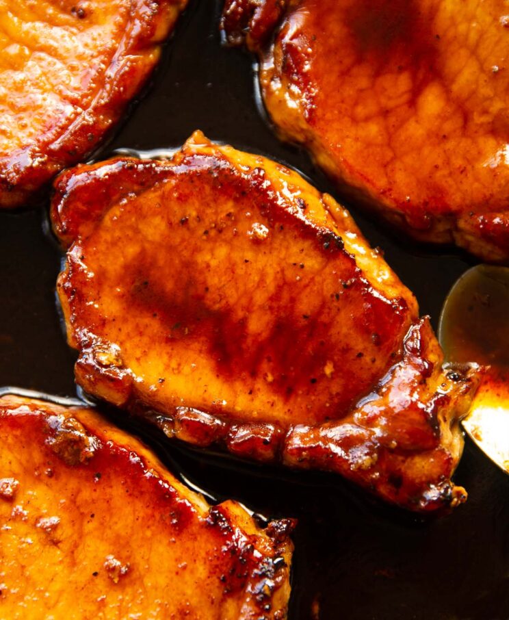 close up overhead shot of brown sugar glazed pork chops in pan