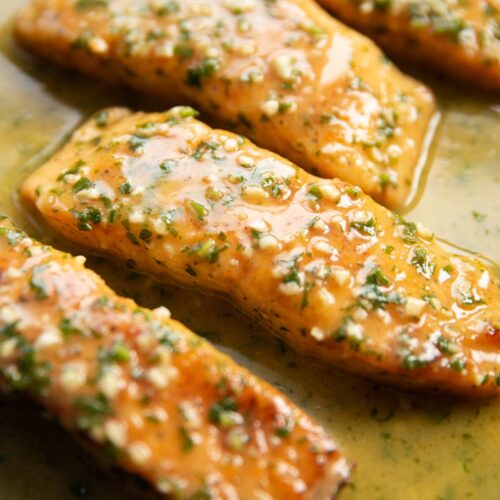 close up shot of garlic butter salmon fillets in pan