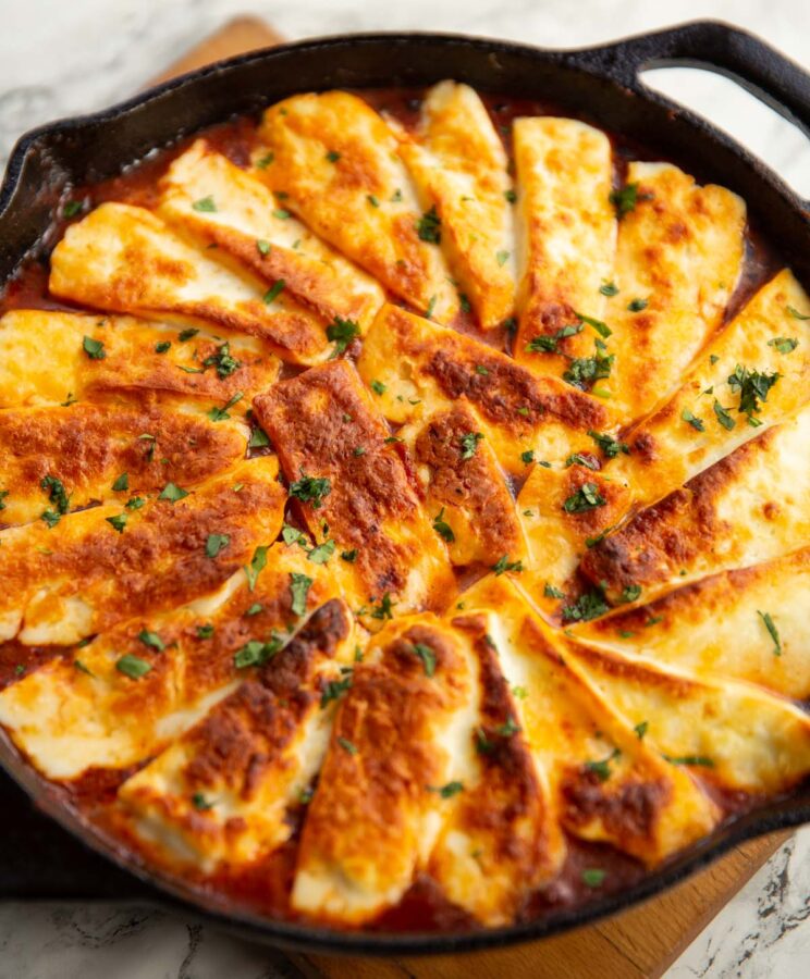 close up shot of halloumi bake fresh out the oven garnished with coriander