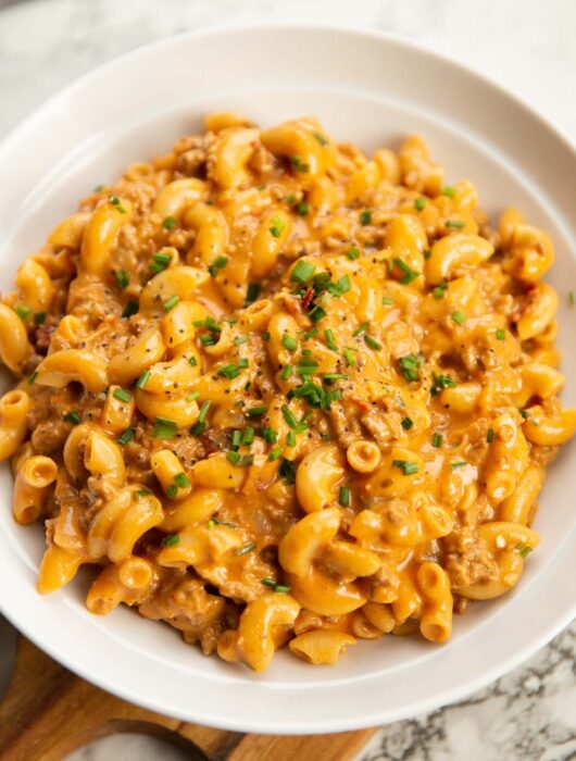 hamburger helper served in a large white bowl with fresh chives
