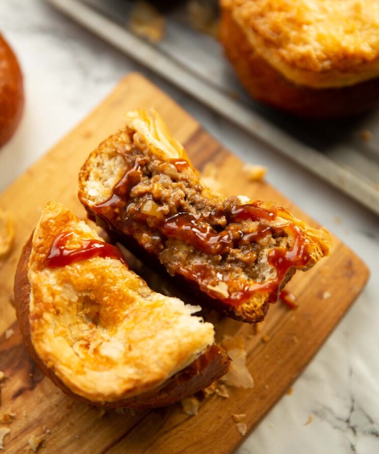 close up shot of beef onion bread roll pie drizzled with brown sauce