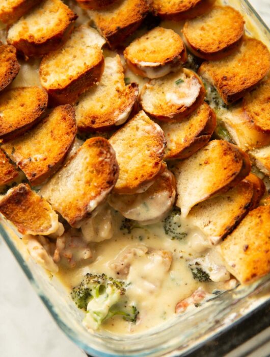close up shot of cheesy chicken broccoli bake with scoop taken out