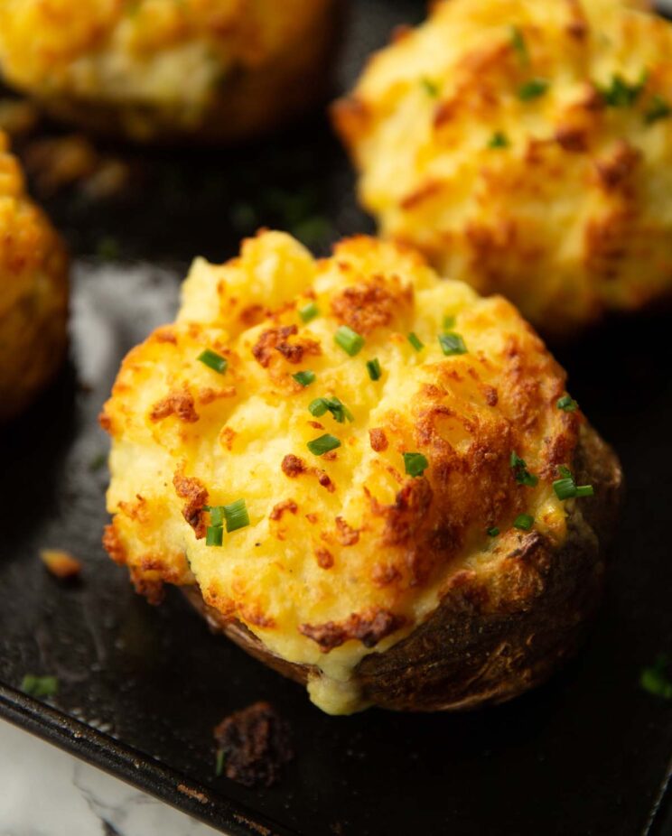 fish pie baked potato fresh out the oven on baking tray garnished with chives