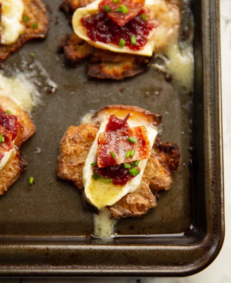 close up shot of brie cranberry bacon potato fresh out the oven on baking tray