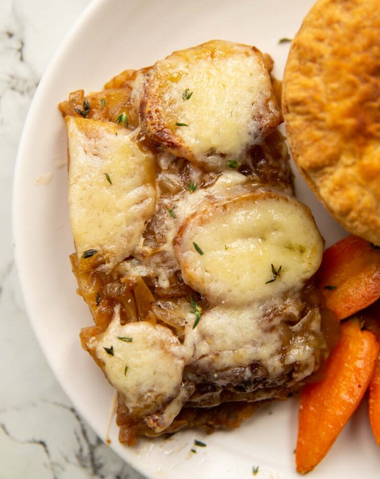 french onion potatoes boulangere served on small white plate with pie and carrots