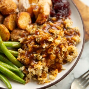 sage and onion stuffing with gravy on small white plate
