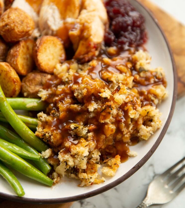 sage and onion stuffing with gravy on small white plate