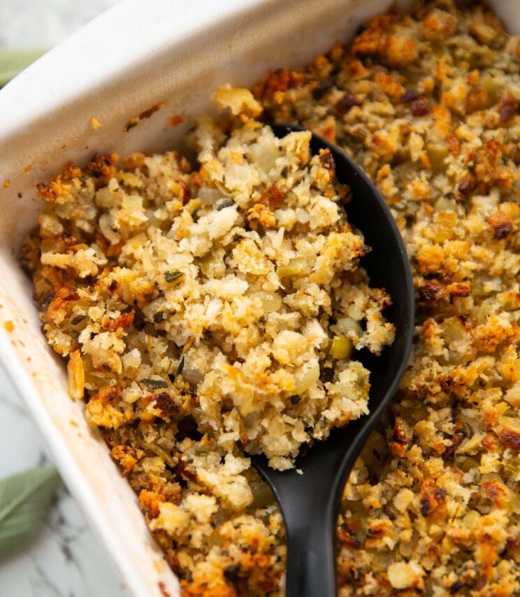 close up overhead shot of serving spoon digging into dish of sage onion stuffing
