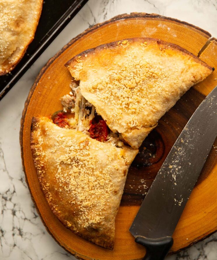 overhead shot of calzone tortilla wrap sliced open on wooden chopping board