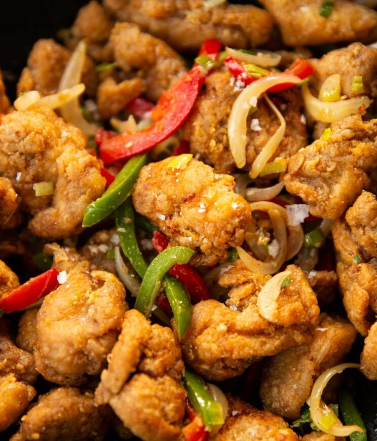 close up shot of salt and chilli chicken in black wok
