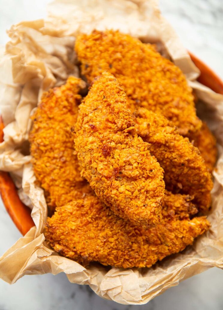 close up shot of Doritos chicken tenders in bowl with brown parchment paper