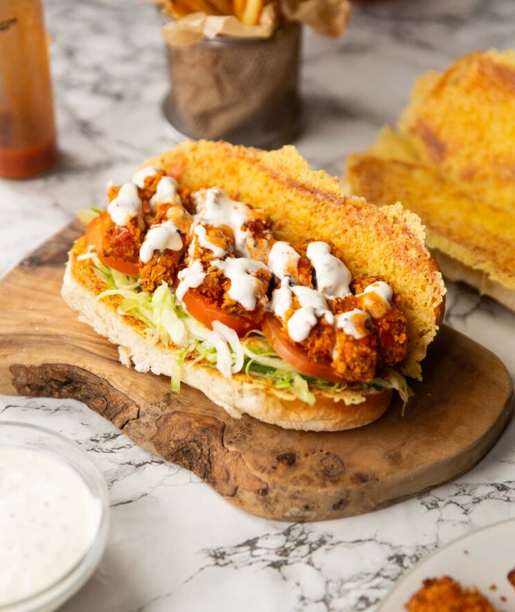 chicken tenders sandwich on wooden board showing filling