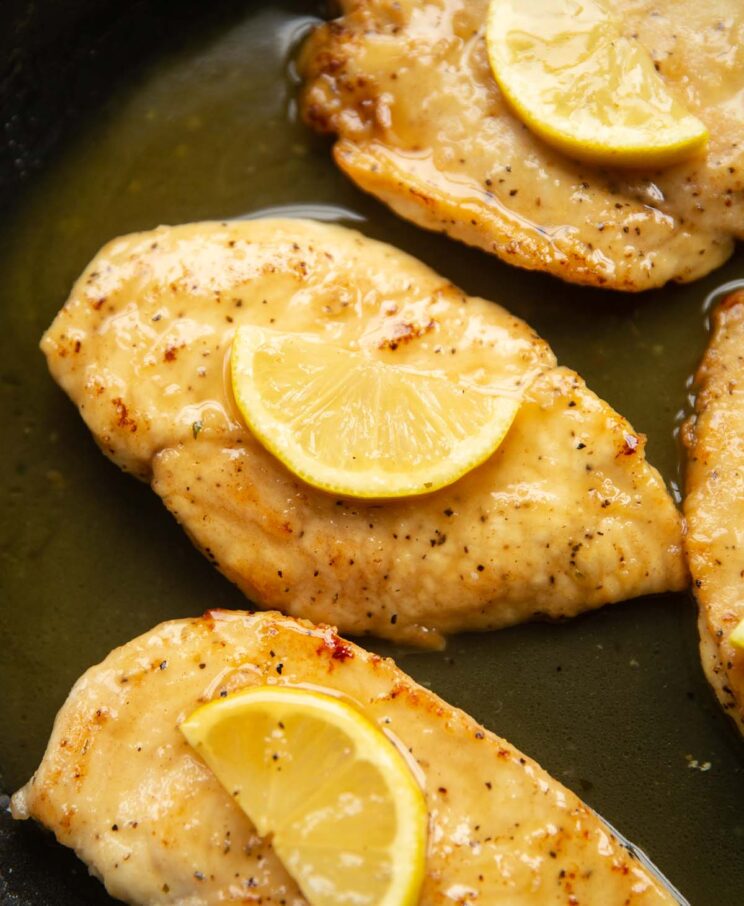 honey lemon chicken in a large pan garnished with lemon wedge