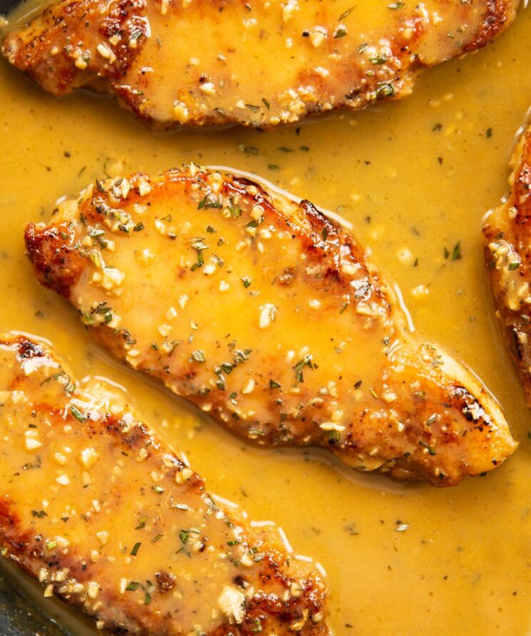 close up of rosemary garlic butter pork chop in pan