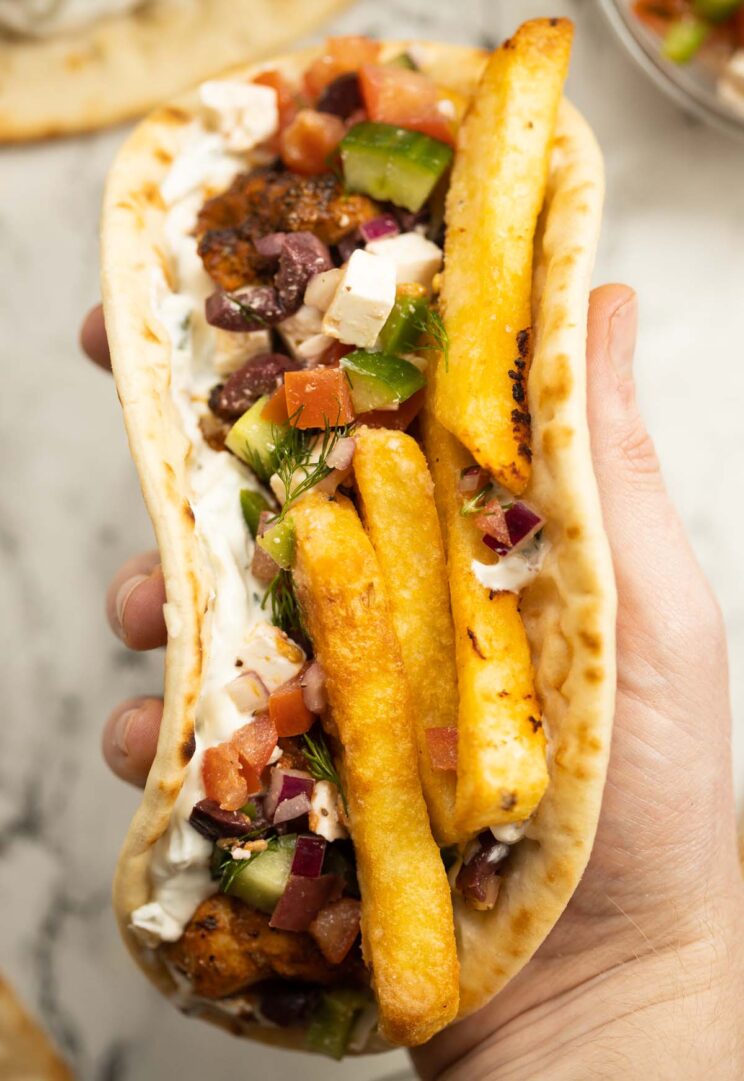 close up overhead shot of hand holding air fryer chicken souvlaki
