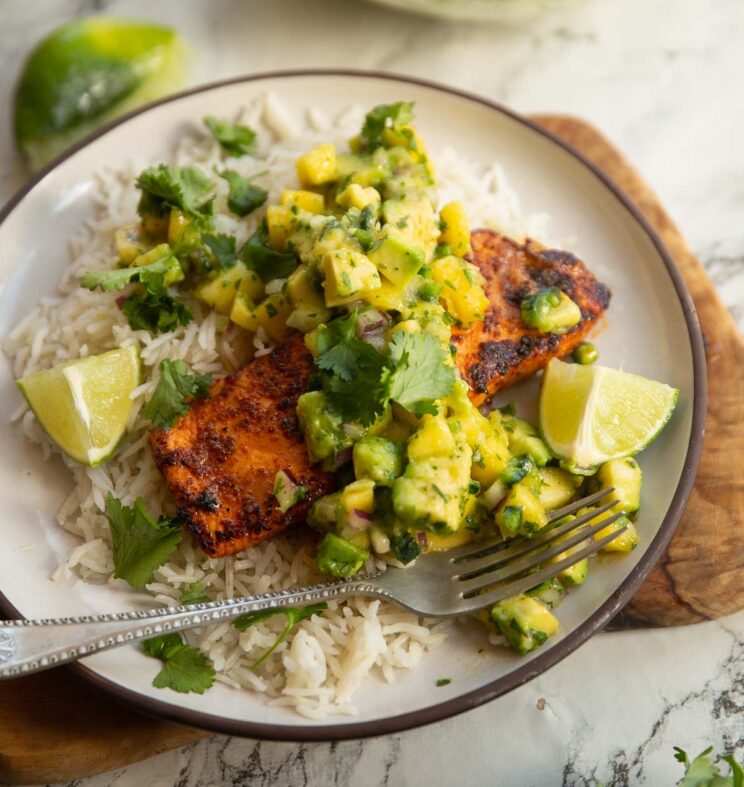 chipotle salmon served with mango salsa on small white plate with rice