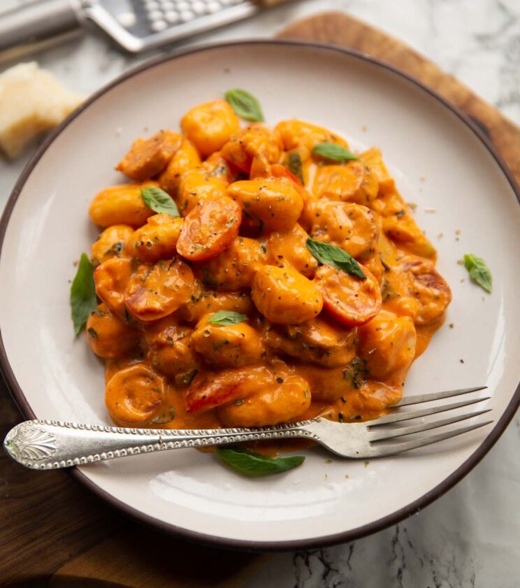 creamy gnocchi chorizo on small white plate with silver fork