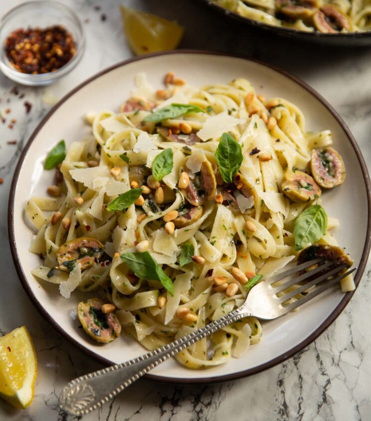 olive pasta served on small white plate with silver fork