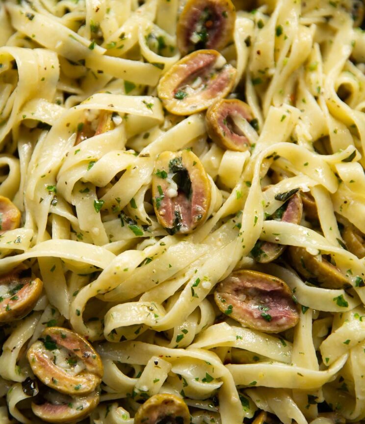 close up shot of pasta with olives in pan
