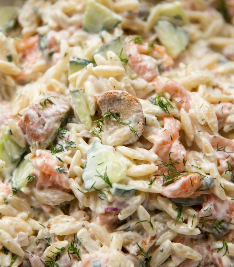 close up shot of salmon pasta salad garnished with dill