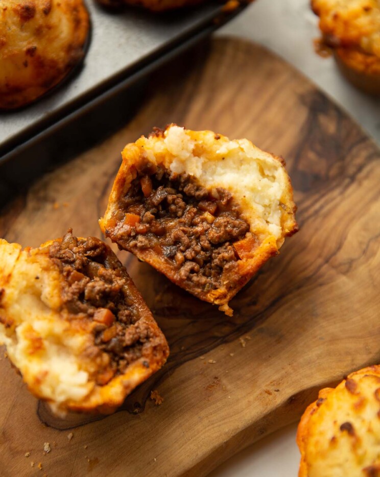 close up shot of mini cottage pie halved on chopping board showing filling