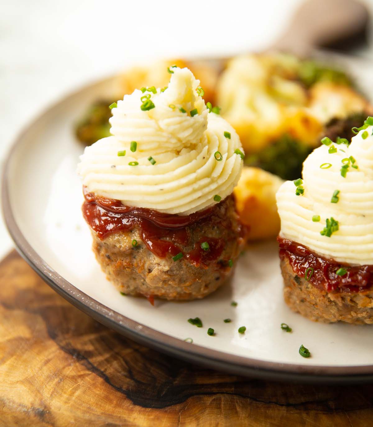 mini meatloaves on small white plate with broccoli and cauliflower