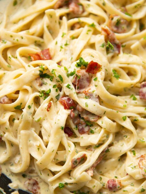 close up shot of creamy bacon pasta in large pan