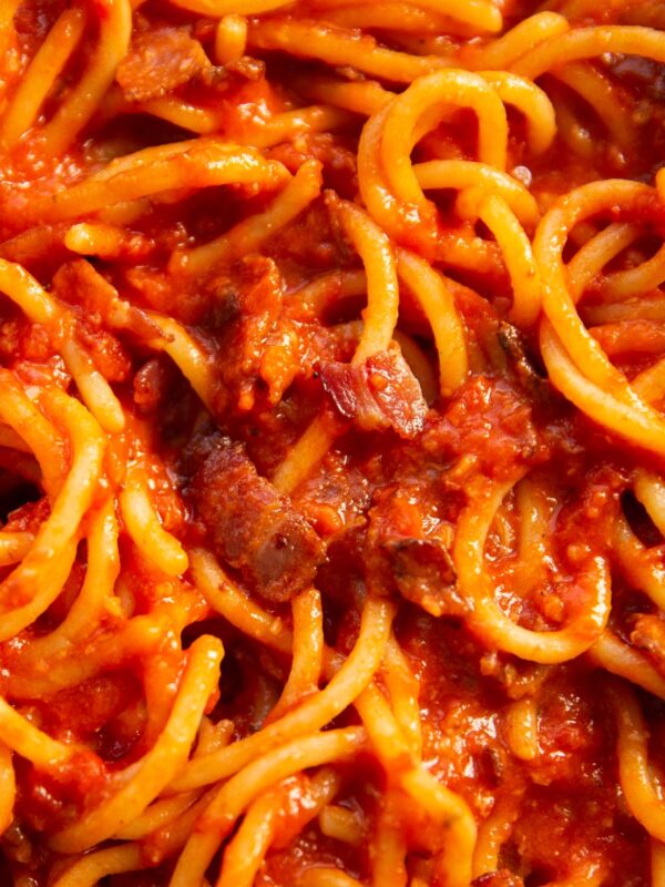 close up overhead shot of tomato bacon pasta in pan