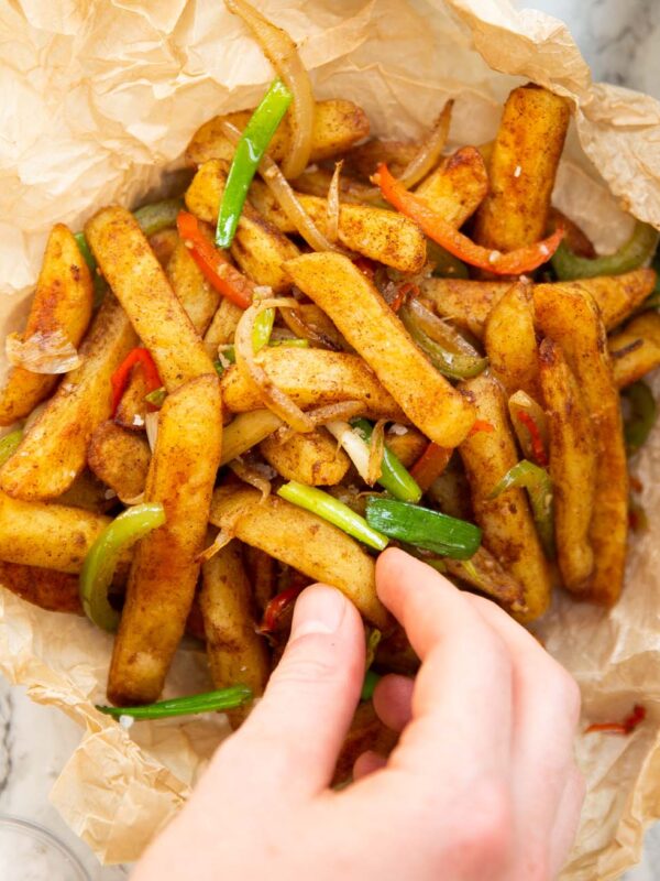 overhead shot of hand grabbing salt and chilli chips