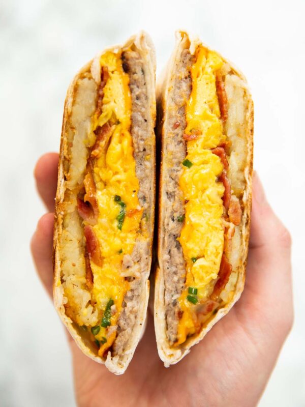 close up overhead shot of hand holding breakfast crunchwrap sliced open